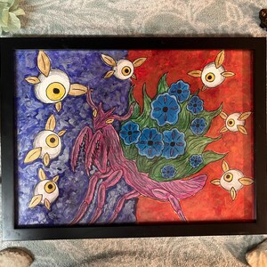 Puede incluir: Una obra de arte rectangular enmarcada que presenta una mantis religiosa morada central rodeada de flores azules sobre un fondo dividido en azul y rojo. Varias criaturas pequeñas, aladas y de ojos amarillos flotan alrededor de la mantis.