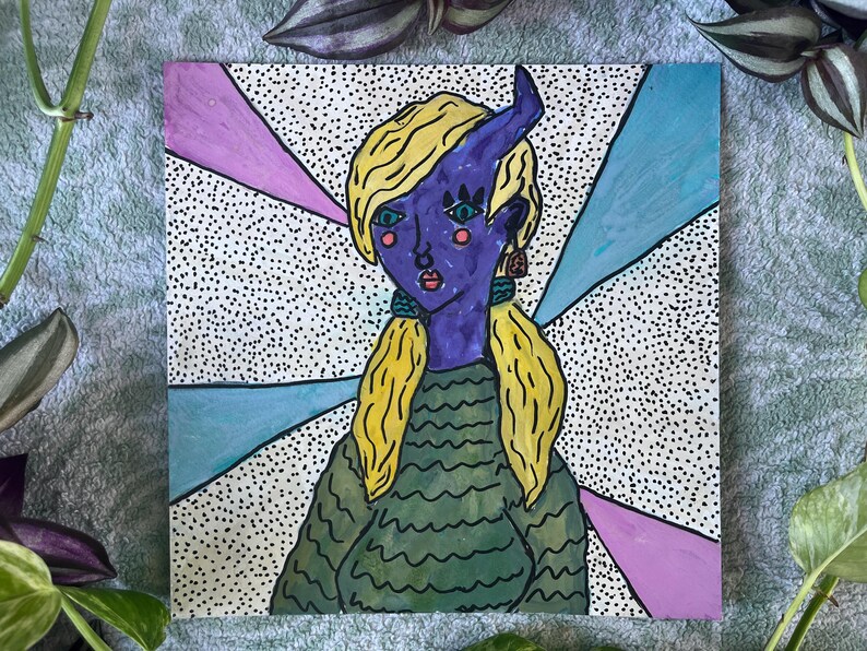 May include: A colorful illustration of a person with purple skin, blonde hair, and a single horn. The person is wearing a green sweater and earrings. The background features a dotted pattern with pink and blue rays.