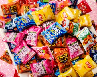 May include: A variety of miniature chip bags in various colors and designs, including Lay's, Bugles, and Clover. The bags are made of foil and have a realistic appearance.