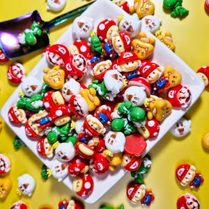 May include: A collection of colorful resin charms featuring cartoon characters and mushroom designs. The charms are red, white, green, yellow, and blue. They are arranged on a white square plate and a small iridescent spoon, set against a yellow background.