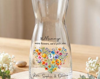 以下が含まれることがあります： さまざまな色のハート型の花柄デザインの透明なガラスの花瓶。花瓶には「If Mummys were flowers, we'd pick you.」と「Love, Sophie & Olivia.」の文字が書かれています。