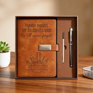 Puede incluir: Un juego de diario de cuero marrón con bolígrafo y lápiz, presentado en una caja de regalo. La portada del diario presenta el texto "FUNNY THINGS MY STUDENTS SAID So I'll never forget" y un gráfico temático de profesor.