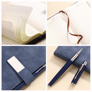 May include: A blue leather-bound notebook with lined pages, a brown ribbon bookmark, and a matching blue pen with silver accents. The notebook has a silver metal clasp.