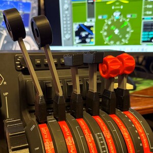 Puede incluir: Primer plano de un conjunto de seis interruptores de control de aeronaves con pomos rojos y negros. Los interruptores tienen etiquetas que dicen "Retire antes del vuelo" y "Recorte".