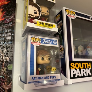 May include: Three Funko Pop vinyl figures on display. The top figure is Post Malone from the Rocks collection. The middle figure is Pat Man and Pups from the Pop Yourself collection. The bottom figure is a South Park character.