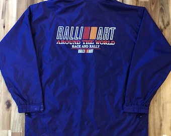 May include: A blue windbreaker jacket with the text "Ralliart Around the World Race and Rally Ralliart" on the back.
