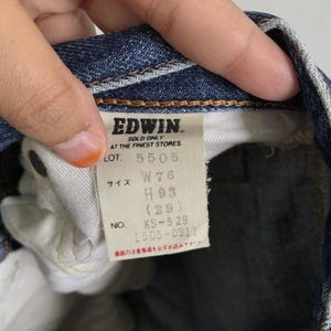Peut inclure: Gros plan sur une &eacute;tiquette de jean bleu. L'&eacute;tiquette indique "EDWIN" et comprend des d&eacute;tails tels que "W76", "H93 (29)" et "KS-529 2505-0911". L'&eacute;tiquette est blanche avec du texte noir.