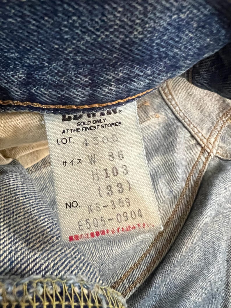 May include: Close-up of a denim jeans label with text. The label reads "SOLD ONLY AT THE FINEST STORES" and includes size information: W 36, H 103 (33). The label also shows the lot number 4505 and the number KS-359.