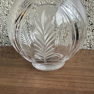 以下が含まれることがあります： カットクリスタルデザインの透明なガラスボウル。ボウルは丸い形と幅広のベースを持っています。デザインは葉の繰り返しパターンを特徴としています。