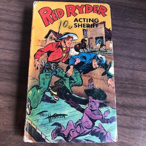 May include: A vintage comic book cover for "Red Ryder Acting Sheriff." The cover displays a vibrant illustration of a cowboy, a Native American, and other characters in a Western setting. The comic book is in good condition.