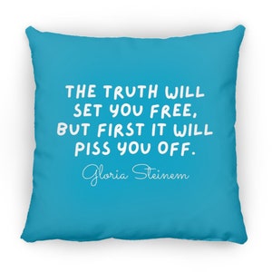 May include: A turquoise blue throw pillow with white text that reads "THE TRUTH WILL SET YOU FREE, BUT FIRST IT WILL PISS YOU OFF." The text is in a handwritten font. The author's name, "Gloria Steinem", is written in cursive below the text.