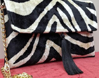 Pochette in velluto con stampa zebrata, borsetta con catena e nappine, accessorio in stile boho.