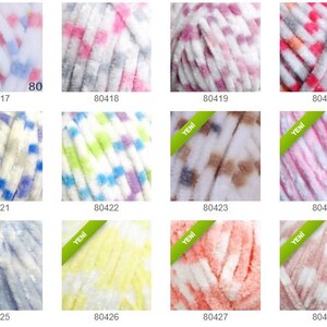 May include: A selection of yarn skeins in various colours and patterns. The yarn has a soft, textured feel, with shades of blue, pink, white, and yellow. Each skein is labelled with a product code. Ideal for knitting and crochet projects.