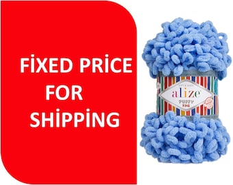 May include: A skein of bright blue Alize Puffy Fine yarn featuring a textured, looped construction. The central paper label displays the brand name Alize, the product name Puffy Fine, and a colorful vertical striped pattern on the background.