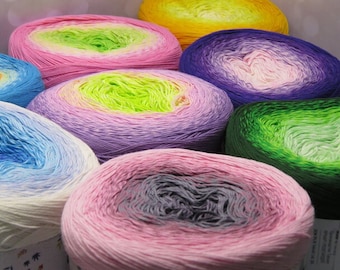 May include: A collection of colorful yarn skeins with ombre dyeing. The skeins are arranged in a circle, with the colors transitioning from light to dark. The colors include pink, green, blue, purple, and yellow.