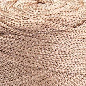 May include: A close-up of a beige braided rope, showing the intricate woven pattern.