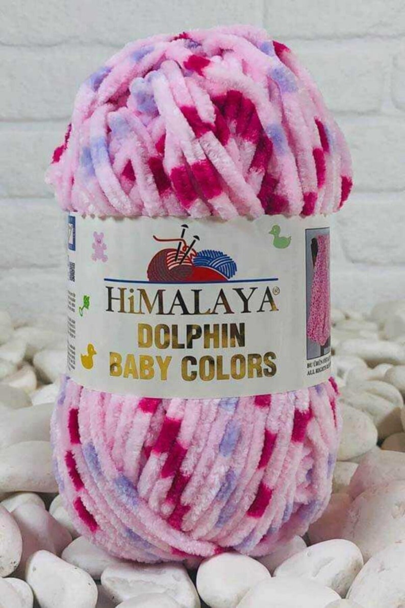 May include: A ball of Himalaya Dolphin Baby Colors yarn in pink, fuchsia, and light blue. The label displays the brand name and product details. The yarn is fluffy and soft, suitable for baby projects.
