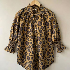 Leopardmönstrad blus, bohemisk skjorta med knappar, senapsgrå djurmönstrad topp, höghalsad tunika med smockad manschett, eleganta arbetskläder, långärmad höstmode