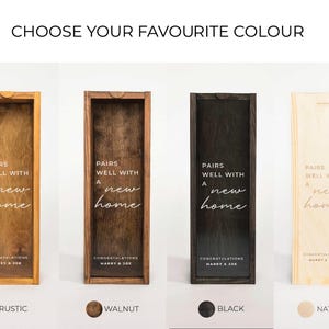 May include: Four wooden boxes with different wood finishes: rustic, walnut, black, and natural. Each box has the text "Pairs well with a new home" and "Congratulations" with a name.