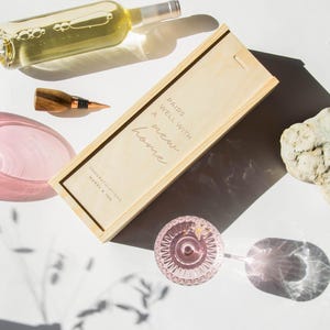 May include: Wooden wine box with the text "Pairs well with a new home" and the names "Congratulations Mary & Joe".