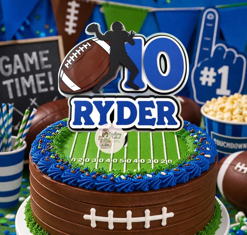 May include: A chocolate frosted cake decorated as a football field with blue frosting and a football-themed cake topper that says "RYDER" and "10". The cake is surrounded by football decorations and a "GAME TIME!" sign.