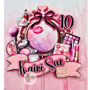 May include: A pink and gold cake topper with makeup-themed decorations. The design includes a mirror, lipstick, eyeshadow, and a banner that reads "Kairi Sue". A large number 10 is also included in the design.