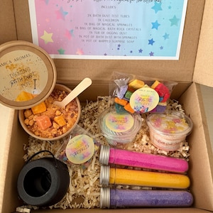 May include: A cardboard box containing an Amica Aromas Magical Large Potion Box set. Items include a black plastic cauldron, three test tubes filled with pink, yellow, and purple bath dust, a pot of digging bath dust, bath rocks, and sprinkles.