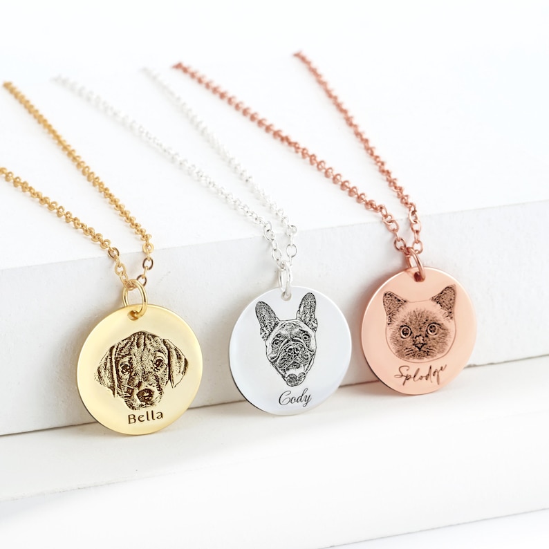 Puede incluir: Tres collares con colgantes circulares en tonos oro, plata y oro rosa. Cada colgante presenta un retrato de mascota grabado con l&aacute;ser y un nombre: Bella, Cody y Splodge. Los collares tienen cadenas met&aacute;licas a juego.