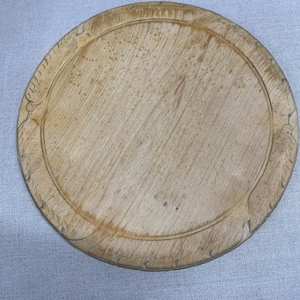 Geschnitztes Vintage Brotbrett aus Holz mit Federdetail.