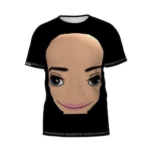 May include: Black t-shirt featuring a large, cartoonish face with big eyes, a pink mouth, and a bald head. The shirt has a white collar and the word "akabald" is printed on the left sleeve.