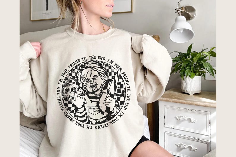 May include: A cream-colored sweatshirt with a black and white graphic of a character from the movie Child's Play. The graphic includes the text "I'm your friend til the end. I'm your friend til the end." and "Chucky".