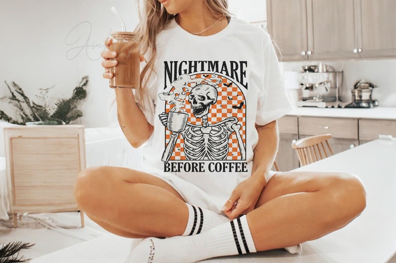 May include: White t-shirt with a graphic of a skeleton holding a coffee cup and the text "Nightmare Before Coffee".
