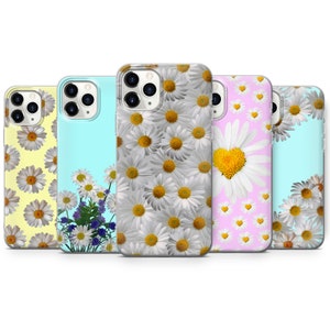 May include: Five different iPhone cases with daisy flower designs. The cases are clear and show the phone's color underneath. The designs include a white daisy pattern, a bouquet of daisies, a daisy with a yellow heart, a pink background with yellow hearts, and a blue background with daisies.