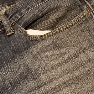 May include: Close-up of a pair of blue denim jeans. The image focuses on the front pocket, showing the stitching and the texture of the denim fabric. The jeans have a classic, worn look.