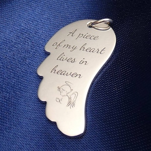 Könnte beinhalten: Silberner Engelsflügel-Anhänger mit der Inschrift "A piece of my heart lives in heaven".