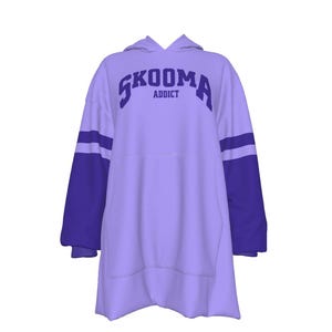 Op de afbeelding: Een lichtpaarse hoodie met de tekst "SKOOMA ADDICT" in donkerpaars over de borst. De mouwen zijn donkerpaars met twee lichtpaarse strepen. De hoodie heeft een grote voorzak en een capuchon.