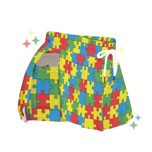 May include: A colourful skirt with a jigsaw piece pattern in shades of blue, yellow, red and green. The skirt has a drawstring waist and a side pocket.