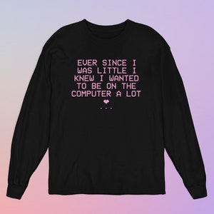 May include: Black long-sleeve shirt with pink text that reads "EVER SINCE I WAS LITTLE I KNEW I WANTED TO BE ON THE COMPUTER A LOT" and a small pink heart.