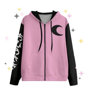 Puede incluir: Sudadera con capucha rosa con cremallera y mangas negras. La manga izquierda tiene texto japonés blanco. Un diseño de media luna negra está en la parte delantera. Tiene un bolsillo frontal.