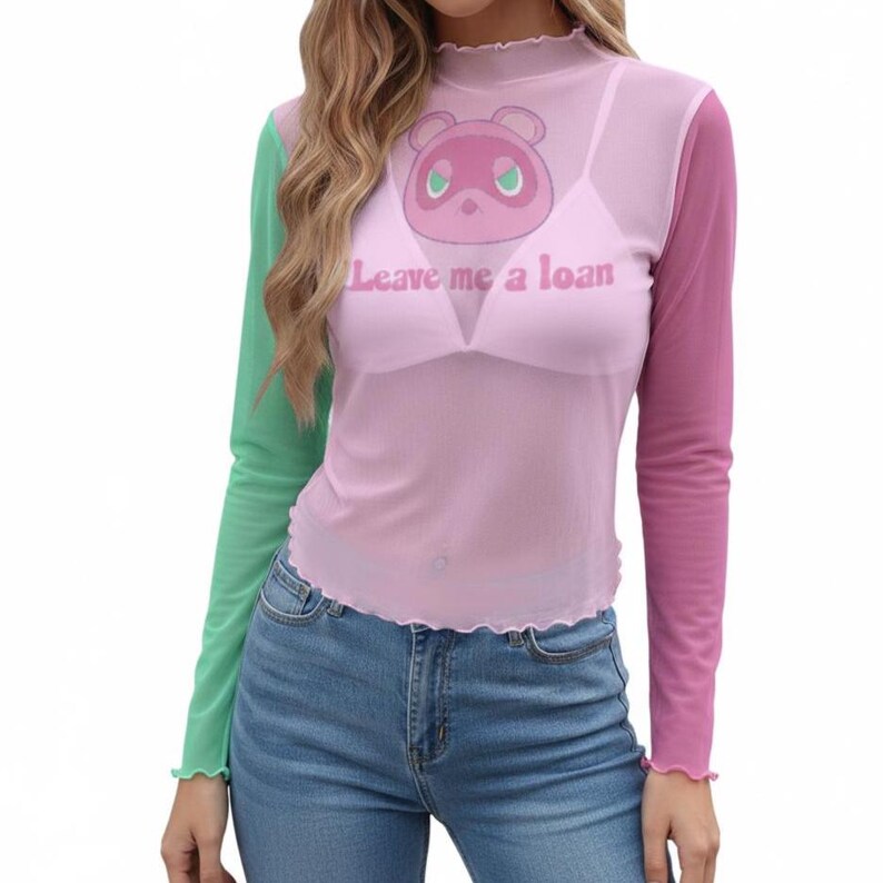 May include: A sheer, long-sleeved top with a colour-block design. The left sleeve is green, the right sleeve is pink, and the body is light pink. The top features a cartoon character and the text "Leave me a loan".