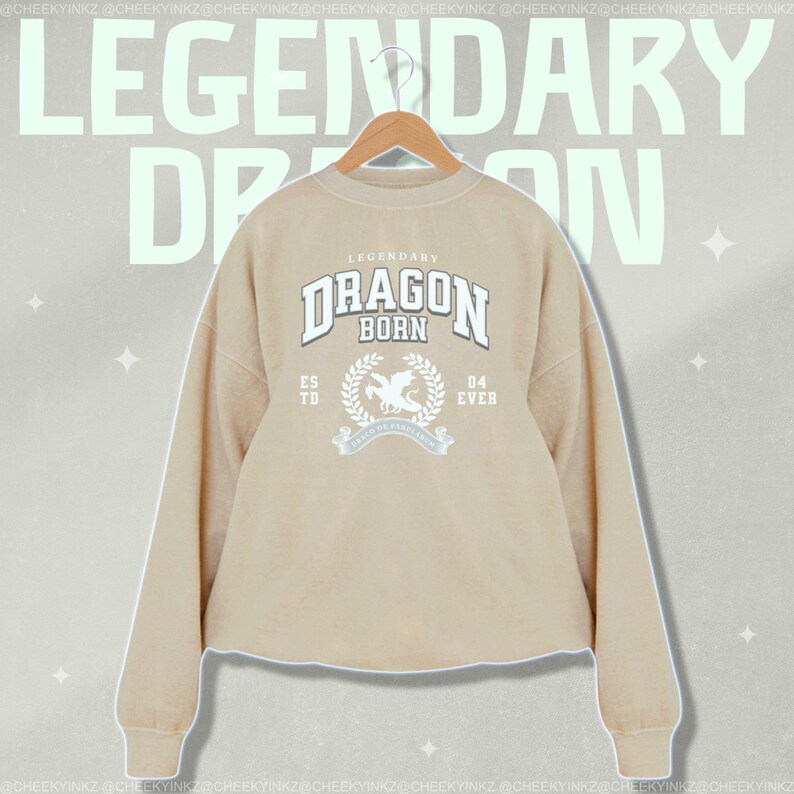 May include: A beige sweatshirt with a white graphic print of a dragon with the text "Legendary Dragon Born" and "Est. 04 Ever".