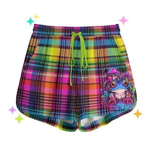 May include: Colourful plaid shorts with a green drawstring and a graphic print of a frog with mushrooms on the right side.