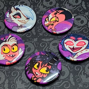 May include: Five round buttons with colorful cartoon characters on a black and purple background. The characters are all from the animated series Helluva Boss.