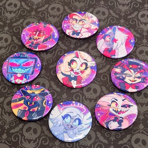 May include: Nine round buttons with different cartoon characters from the animated series Helluva Boss. The buttons are on a dark purple background with a skull pattern.