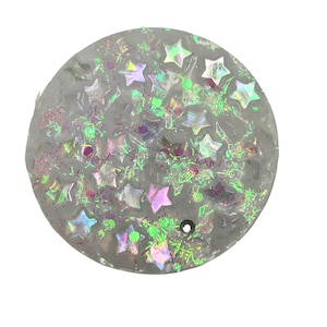 May include: A round, clear, resin coaster with iridescent glitter and star-shaped confetti.