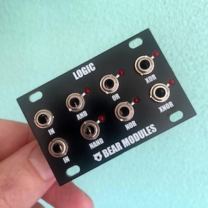 Puede incluir: Módulo electrónico negro con interruptores basculantes y luces indicadoras rojas. El módulo tiene la palabra "LOGIC" en la parte superior y las palabras "AND", "OR", "NOR", "XOR" y "XNOR" impresas. El texto "BEAR MODULES" también está impreso en el módulo.