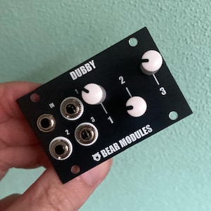 May include: Black Dubby audio module with three knobs and three input jacks. The module has the text "DUBBY" and "BEAR MODULES" printed on it.