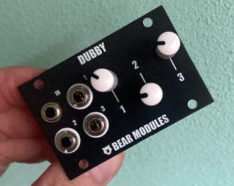 May include: Black Dubby audio module with three knobs and three input jacks. The module has the text "DUBBY" and "BEAR MODULES" printed on it.
