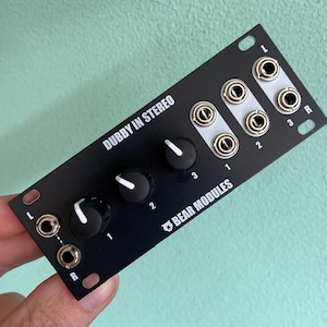May include: Black Dubby In Stereo Eurorack module with three knobs and three 1/4 inch jacks labeled L, 1, 2, 3, R. The module is labeled "Dubby In Stereo" and "Bear Modules".