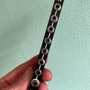 Puede incluir: Módulo blanco y negro con el número "71" impreso en él. El módulo tiene 10 conectores redondos plateados con anillos blancos alrededor. Un logotipo de cara de oso blanco está impreso en la parte inferior del módulo.